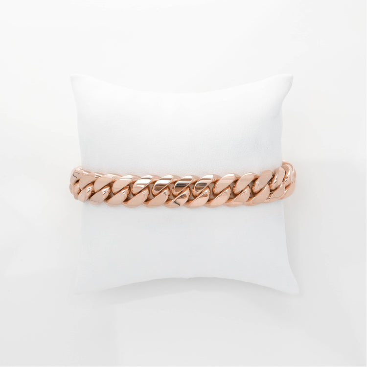 The 12mm Handmade Miami Cuban Link Bracelet in solid gold (10K/14K/18K) is shown in rose gold, resting on a white cushioned pillow against a plain white background.