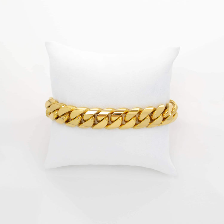 The 13mm Handmade Miami Cuban Link Bracelet in 10K, 14K, or 18K solid gold is showcased on a white pillow against a plain white background.