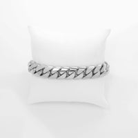The Cuban Link Bracelet - 13mm Solid Gold is displayed on a white cushioned pillow against a plain white background.