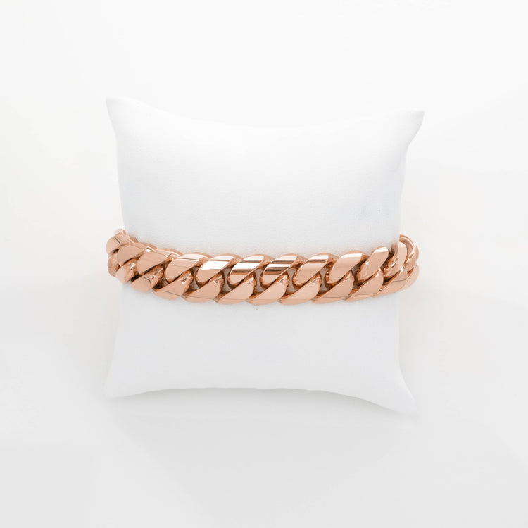 A 13mm Handmade Miami Cuban Link Bracelet in solid 10K, 14K, or 18K gold is displayed on a small white cushion against a white background.
