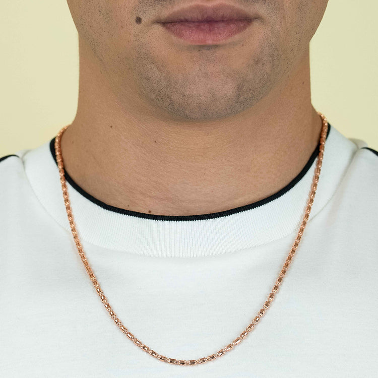 A person wears a white shirt with black trim and a 3mm Barrel Crystal Chain - 14k Rose Gold Bonded necklace. Only the lower half of their face and neck are visible.