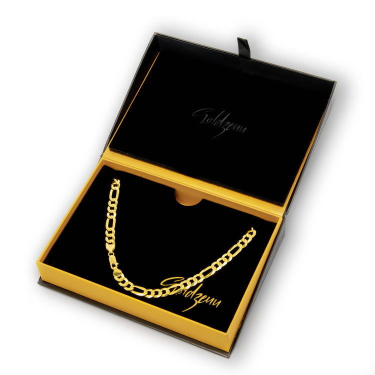 The Figaro Chain 8mm - 14k Gold Bonded is displayed in an open black and gold Goldzenn jewelry box. This men’s chain features a durable, luxurious 14K Gold Bonded finish for lasting shine, with the brand name printed inside the lid.