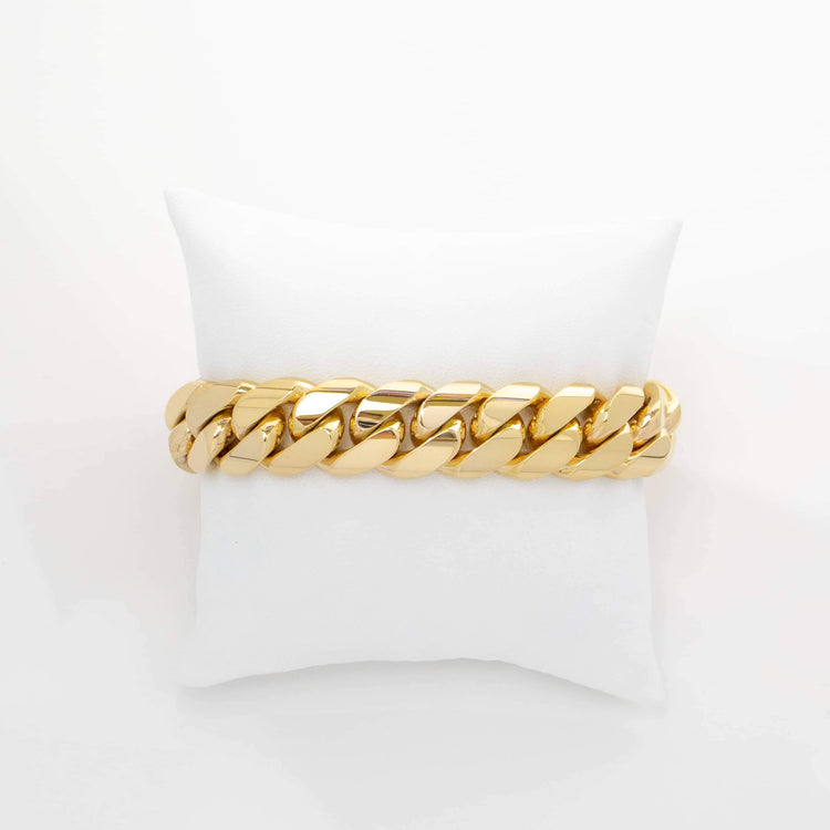 A 16mm Handmade Miami Cuban Link Bracelet in 10K/14K Solid Gold is displayed on a white cushioned pillow against a plain white background.