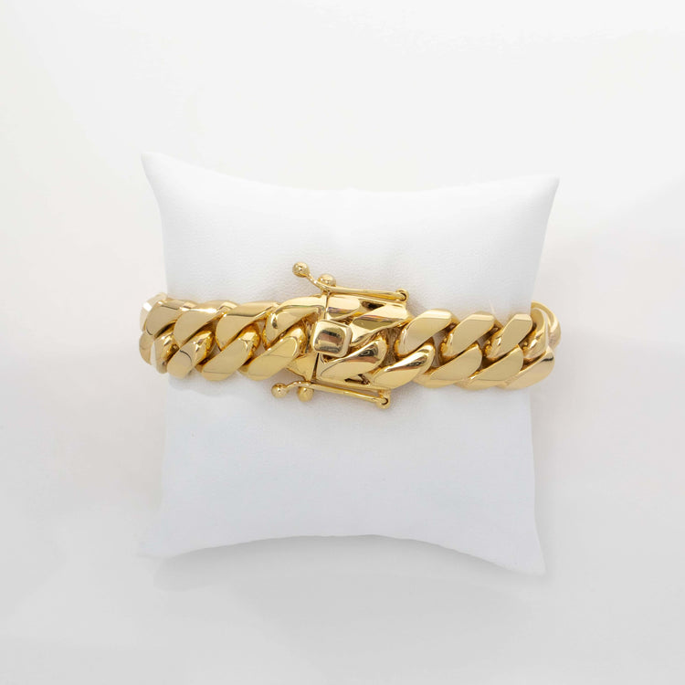 The 16mm Handmade Miami Cuban Link Bracelet in 10K/14K Solid Gold features a box clasp and is displayed on a white cushioned pillow against a plain white background.