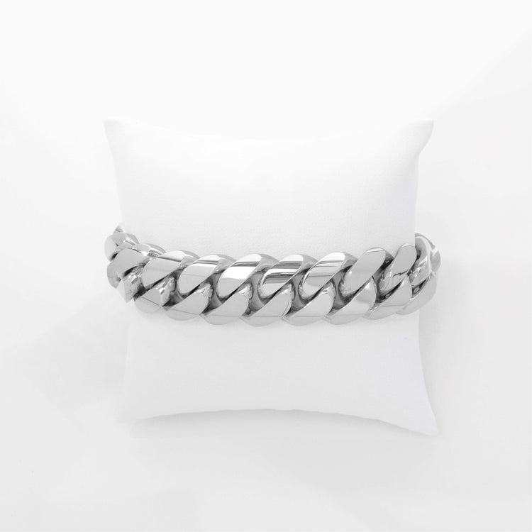 The 18mm Handmade Miami Cuban Link Bracelet in 10K/14K solid gold rests on a white cushion, showcased against a plain white background.