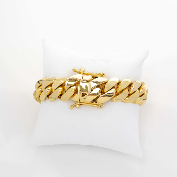 The 18mm Handmade Miami Cuban Link Bracelet in 10K/14K Solid Gold features a chunky design and box clasp, showcased on a white cushion with a simple, light background.