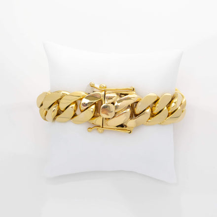 The 19mm Handmade Miami Cuban Link Bracelet in 10K/14K Solid Gold, featuring a T-bar clasp, is displayed on a white cushioned pillow against a plain white background.