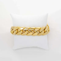 The Cuban Link Bracelet - 19mm Solid Gold is showcased on a white cushion against a plain white background.