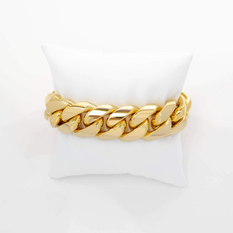 The 20mm Handmade Miami Cuban Link Bracelet in 10K/14K solid gold shines on a white cushioned pad, set against a plain white background.