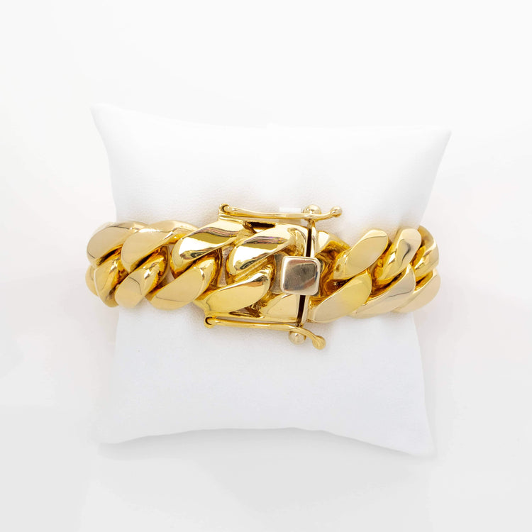 The 20mm Handmade Miami Cuban Link Bracelet in 10K/14K solid gold features a chunky design and square clasp, showcased on a white cushion with a plain white background.