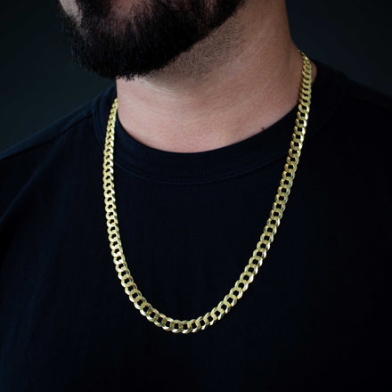 A person wears the Curb Link Chain - 8mm 14k Gold Bonded over a plain black t-shirt, with only the lower half of their face and neck visible against a dark background.