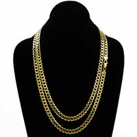 A black velvet jewelry bust showcases two layered men's gold chain necklaces, featuring the Curb Link Chain - 8mm 14k Gold Bonded with flat, interlocking links for a bold and elegant look.