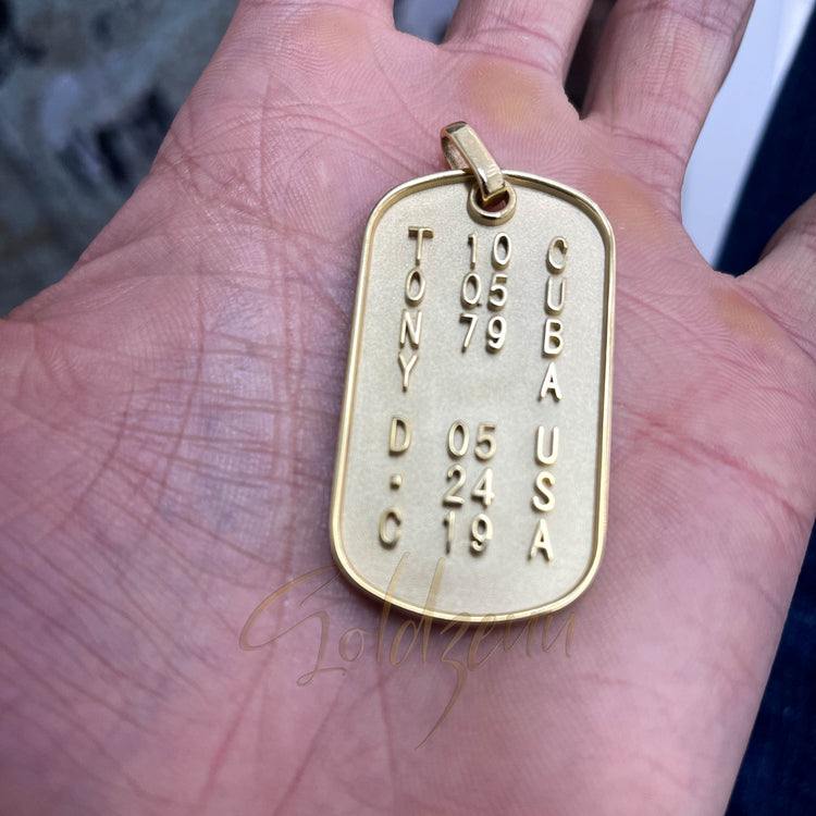 A Custom Military/Dog Tag Pendant engraved with TONY, numbers, CUBA USA, and D.C. is displayed in a hand. The personalized pendant includes dates and a top loop for attaching to a chain.
