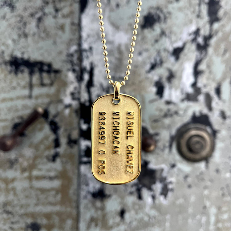 A Custom Military/Dog Tag Pendant on a chain, designed as a personalized gold dog tag for a unique touch.