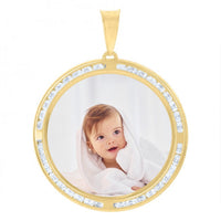 The Custom Picture Pendant Bezel Frame in 10k solid gold, bordered with clear gemstones, displays a baby photo: smiling, wrapped in a white towel, and gazing slightly to the side.