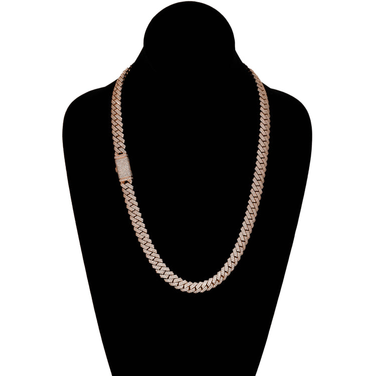 The Diamond Cuban Link Chain – 8mm-17.5mm Solid Rose Gold is shown on a black velvet bust, featuring a rectangular clasp adorned with small, sparkling diamonds.