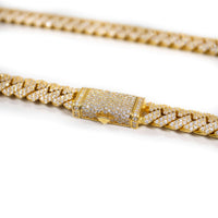 A close-up of the Diamond Cuban Link Chain Prong - Solid Yellow Gold, encrusted with diamonds and featuring a rectangular diamond-studded clasp, shown against a white background.