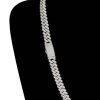 The Diamonds Cuban Link Chain - 8mm-17.5mm Solid White Gold is displayed diagonally on a black velvet stand, encrusted with small, sparkling natural diamonds.