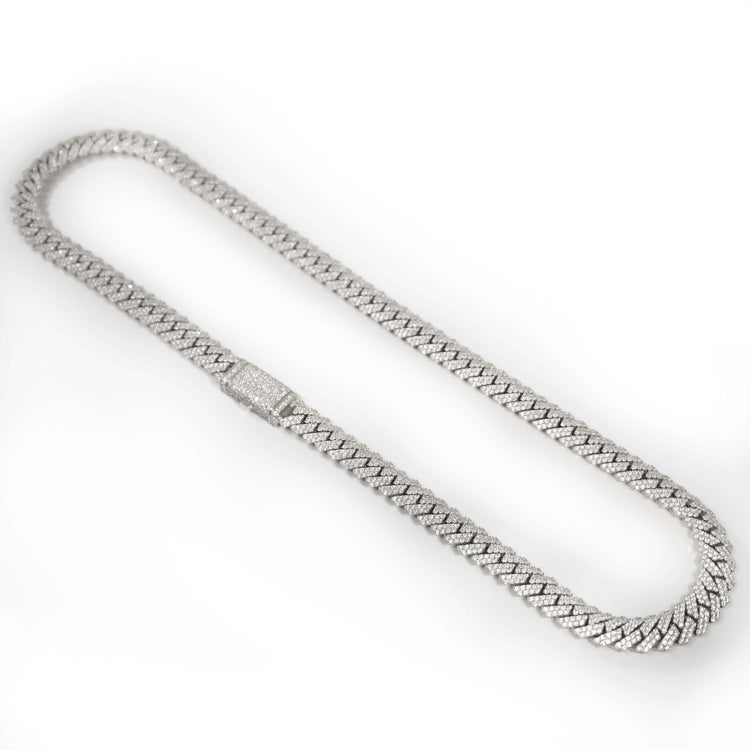 The Diamonds Cuban Link Chain, available in solid white gold (8mm-17.5mm), features a statement Cuban link design and a clasp adorned with sparkling natural diamonds, shown on a white background.