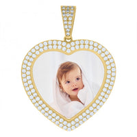 The Heart Frame Charm Picture Pendant in 10k Solid Gold features a heart-shaped design with small diamonds and displays a photo of a smiling baby with light brown hair wrapped in a white towel, creating a timeless personalized accessory.