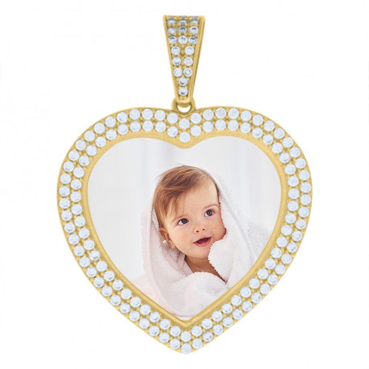 The Heart Frame Charm Picture Pendant in 10k Solid Gold features a heart-shaped design with small diamonds and displays a photo of a smiling baby with light brown hair wrapped in a white towel, creating a timeless personalized accessory.