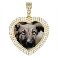 The Heart Frame Charm Picture Pendant in 10k Solid Gold is heart-shaped, diamond-encrusted, and features a close-up photo of a blue-eyed dog inside its personalized picture frame.