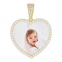 The Heart Picture Pendant in 10k Solid Gold is a heart-shaped pendant outlined with small white gems, featuring a photo of a smiling baby wrapped in a white towel.