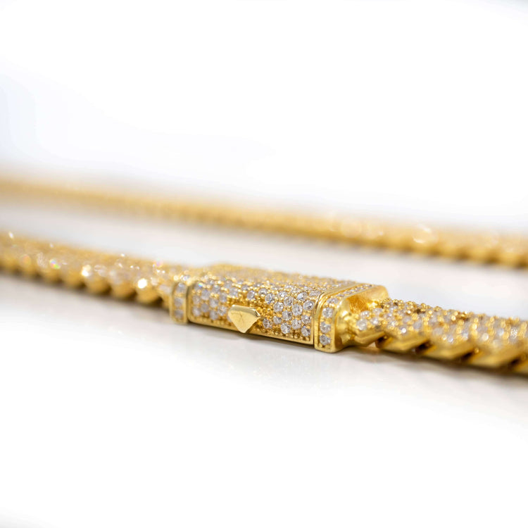 A close-up of the Moissanite Cuban Link Chain 8mm-23mm in solid yellow gold, featuring a rectangular diamond-encrusted clasp, set against a white background.