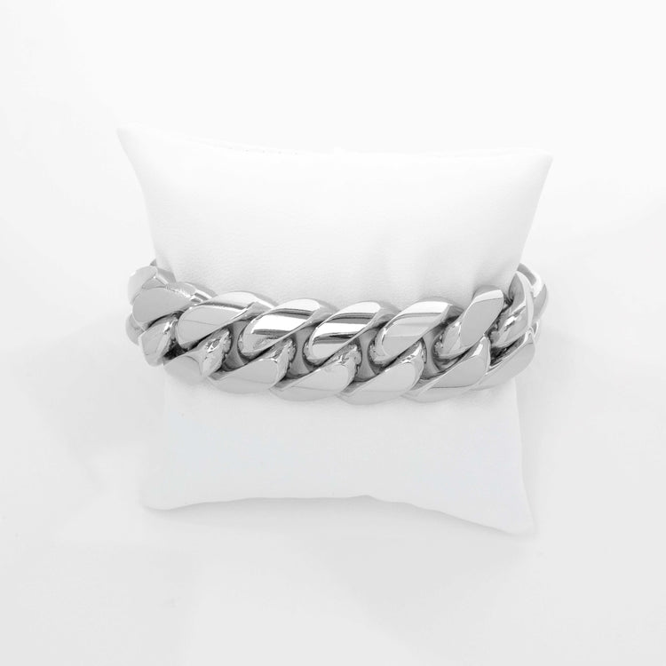 The 20mm Handmade Miami Cuban Link Bracelet in 950 Silver sits elegantly on a white cushioned pillow—bold, polished wristwear that stands out on any occasion.