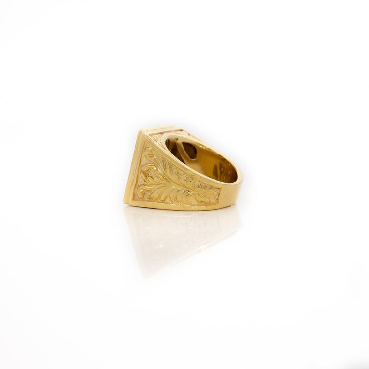The Square Cluster Ring in Solid Gold is displayed on a white reflective surface, showcasing its ornate side engraving, square face, and elegant detailing for a refined look.