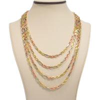A mannequin displays the Tricolor Milano Figarope - 4.5mm 14k Solid Gold necklace, featuring Italian craftsmanship with four elegant layers in yellow, rose, and white gold tones draping gracefully at varied lengths.