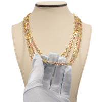 A gloved hand displays the Tricolor Milano Figarope - 4.5mm 14k Solid Gold necklace on a beige stand, featuring Italian craftsmanship and yellow, white, and rose gold links in a layered design.