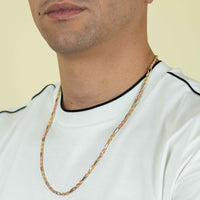 A man in a white T-shirt with black trim wears the 3.5mm Tricolor Milano Figarope Chain—crafted in 14k solid gold—around his neck. Only his lower face and upper torso are shown against a plain background.