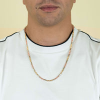 A person wearing a white shirt with black trim and the 3.5mm Tricolor Milano Figarope Chain in 14k solid gold, shown from shoulders to just below the nose against a plain background.
