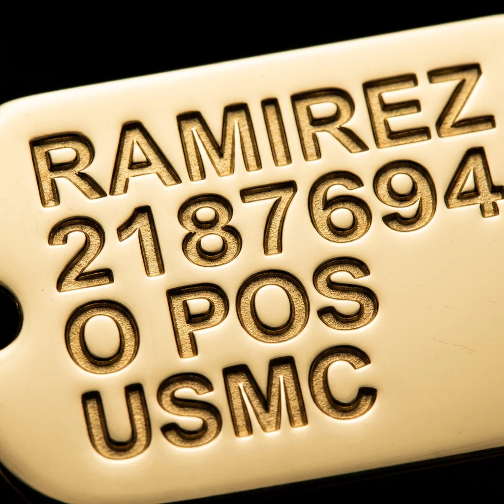 Close-up macro photo of custom engraving on a solid gold dog tag pendant, letters and numbers deeply cut into the gold surface with dramatic side lighting