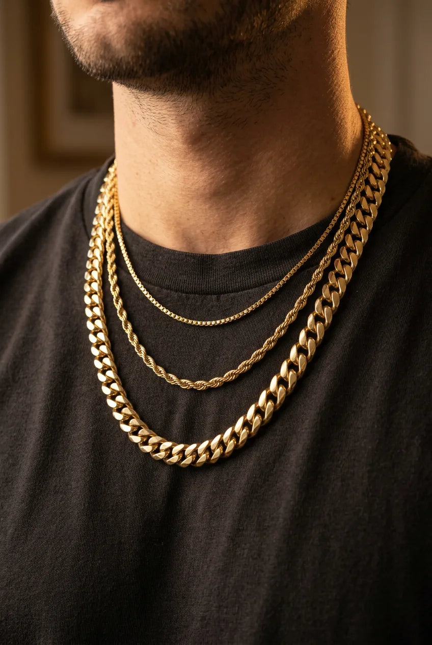 Three different gold chain types layered on neck showing box chain, rope chain, and Cuban link chain at different lengths