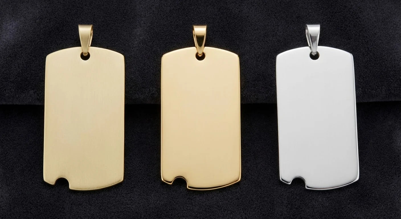 Three solid gold military dog tag pendants showing color difference between 10K, 14K gold and sterling silver, laid on dark velvet — overhead studio photography