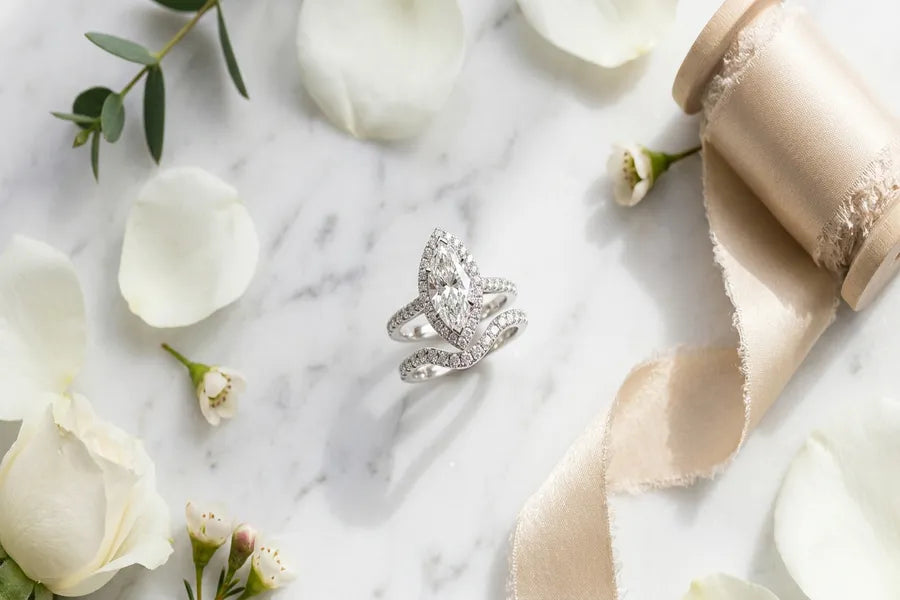 GOLDZENN marquise diamond bridal set in white gold on marble surface with soft natural lighting and bridal accessories