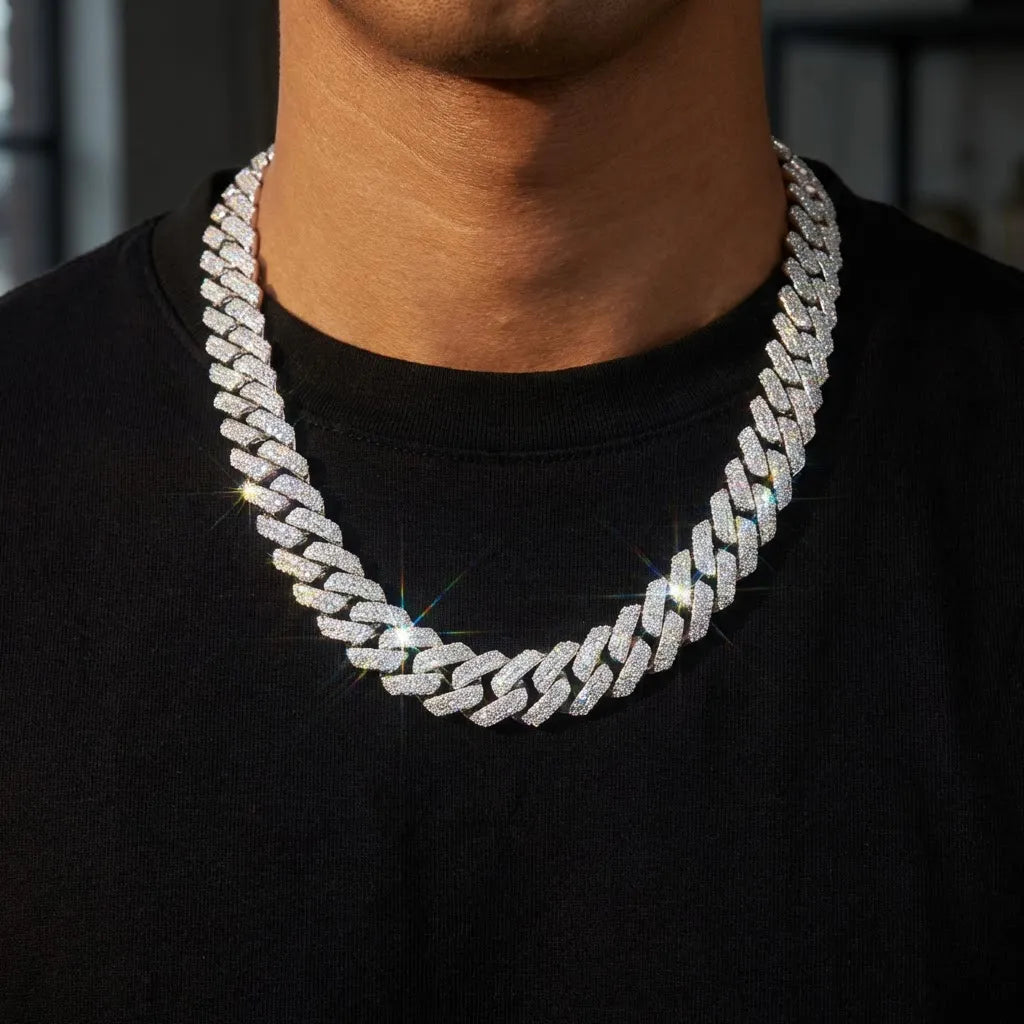Stylish man wearing a thick iced-out moissanite Cuban link chain against a dark shirt, the moissanite stones sparkling with brilliant white light and rainbow fire reflections