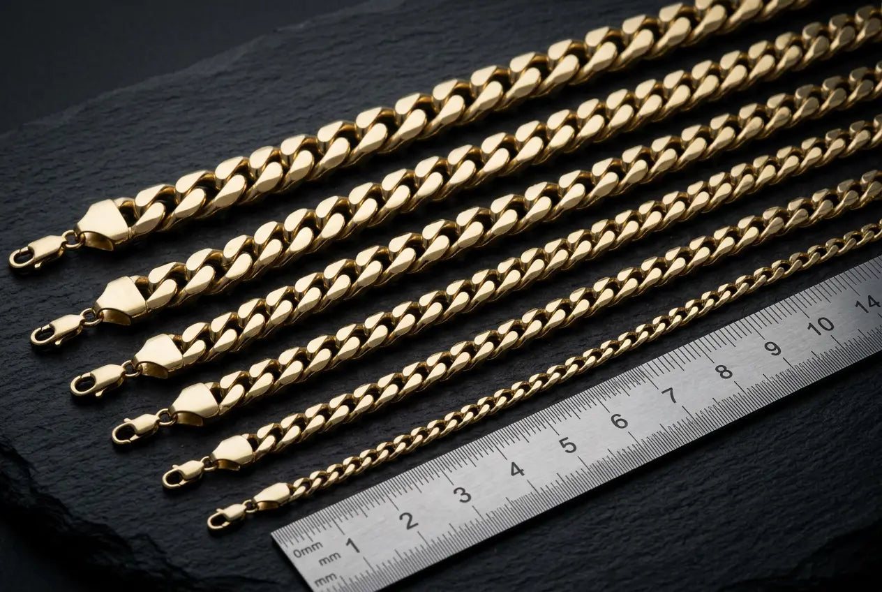 Cuban link chain width comparison from 2mm to 14mm showing seven widths side by side on dark surface with ruler
