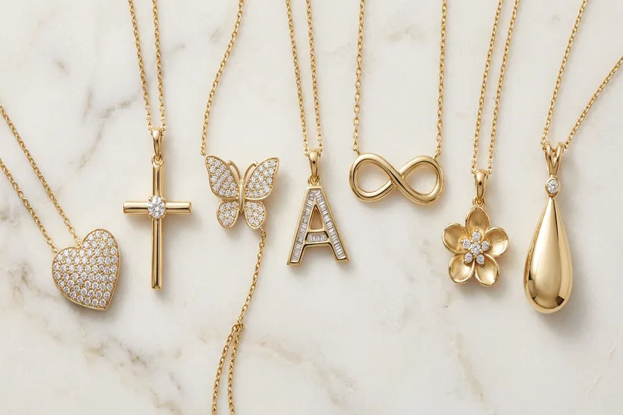 Collection of gold pendant styles for women — heart, cross, butterfly, initial letter, infinity symbol, flower, and teardrop pendants in yellow gold with diamonds