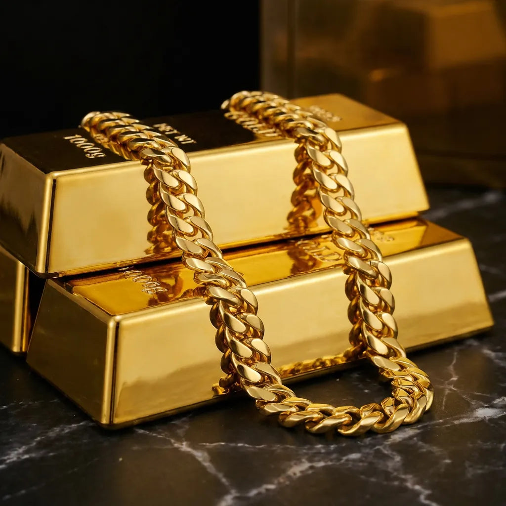 Gold bars stacked on dark marble surface with solid gold Cuban link chain draped across them, warm golden lighting